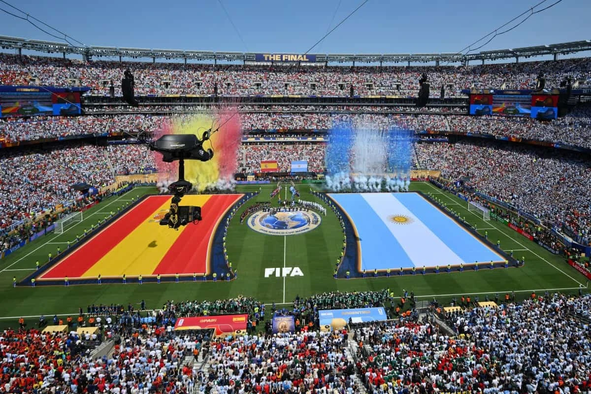 Las banderas de España (izquierda) y Argentina ondean mientras los jugadores permanecen de pie durante la ceremonia de clausura previa a la final del Mundial de Fútbol de 2026 entre España y Argentina en el estadio New York/New Jersey en East Rutherford, el 19 de julio de 2026. (Foto de ANGELA WEISS / AFP)